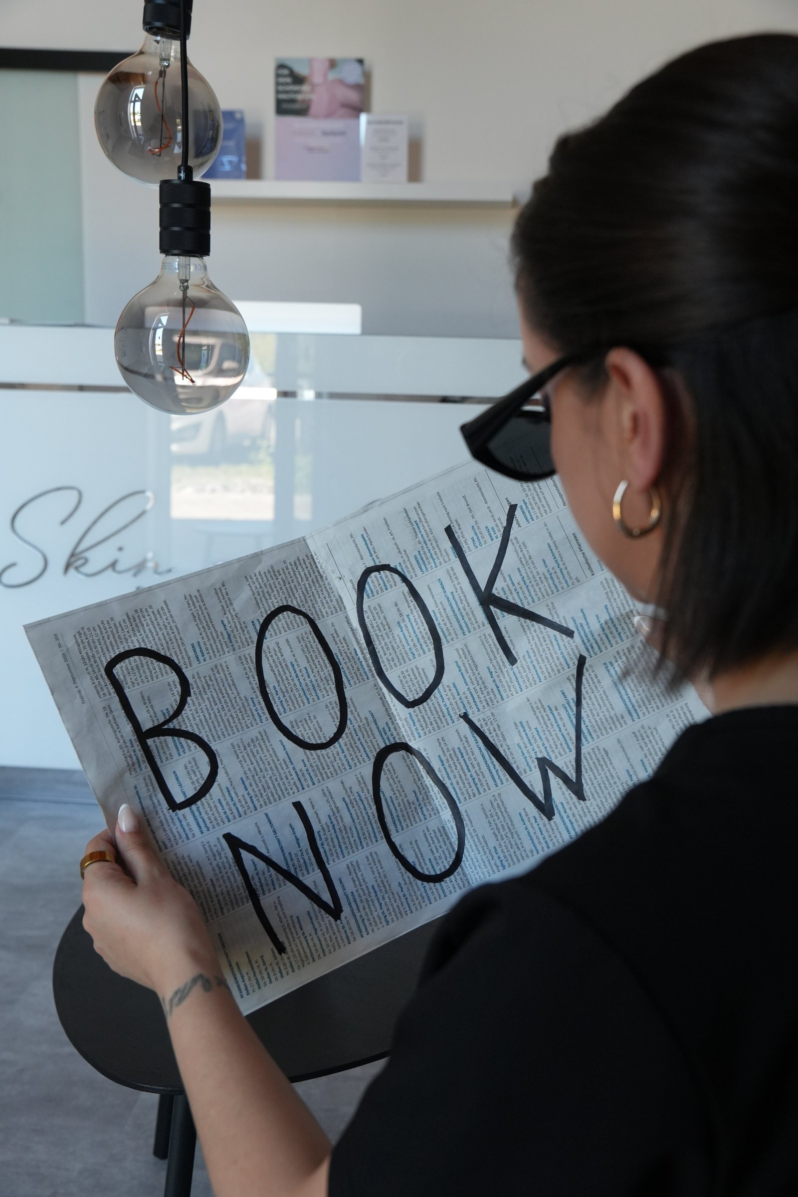 Patricia mit Book-Now-Zeitung im Studio